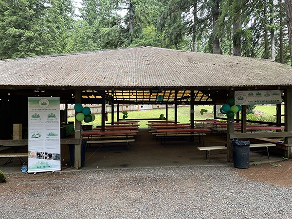 The big covered pavilion of Venue 2 at Alderbrook with picnic tables and Heritage NW Group signs and decorations