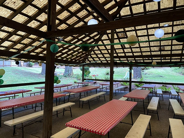 The big covered pavilion of Venue 2 at Alderbrook with picnic tables and Heritage NW Group signs and decorations