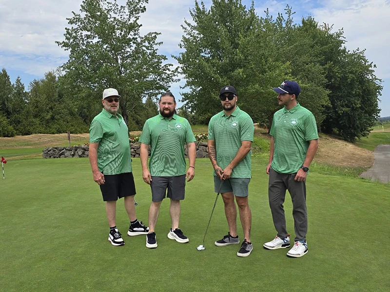 The Heritage NW Group golf team stands together on the green.