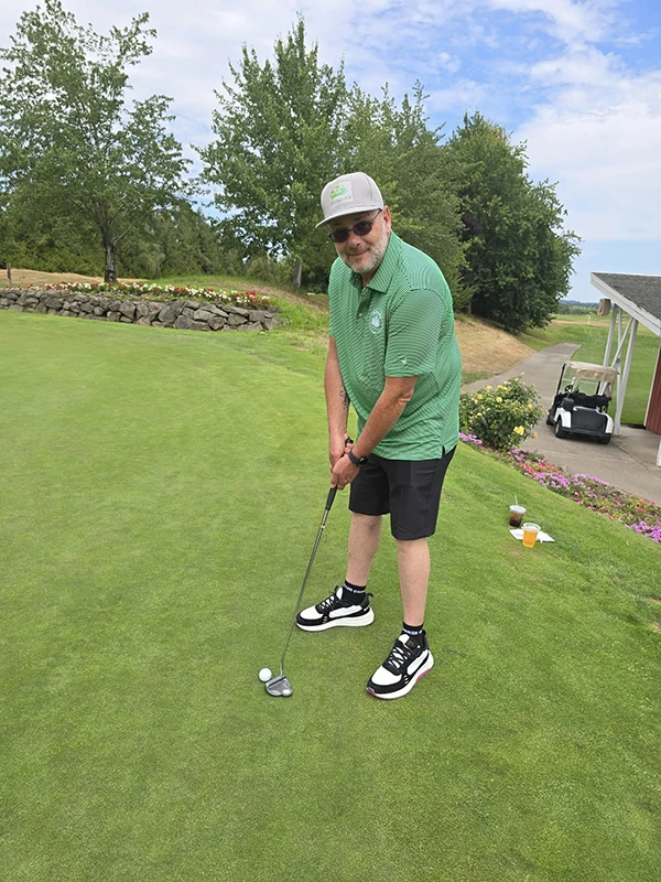 Jim, wearing a green Heritage shirt, lines up a putt at the tournament.