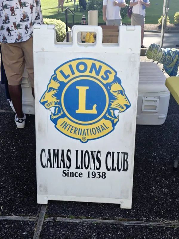 A sandwich board style sign that has the Lions Club logo and the words Lions International Camas Lions Club Since 1938