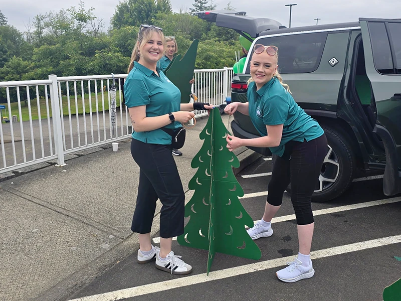 The team works together to decorate the carts with Heritage themed giant trees.