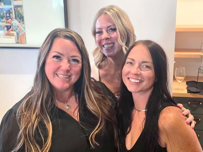 Tara and two other women smile for the camera.